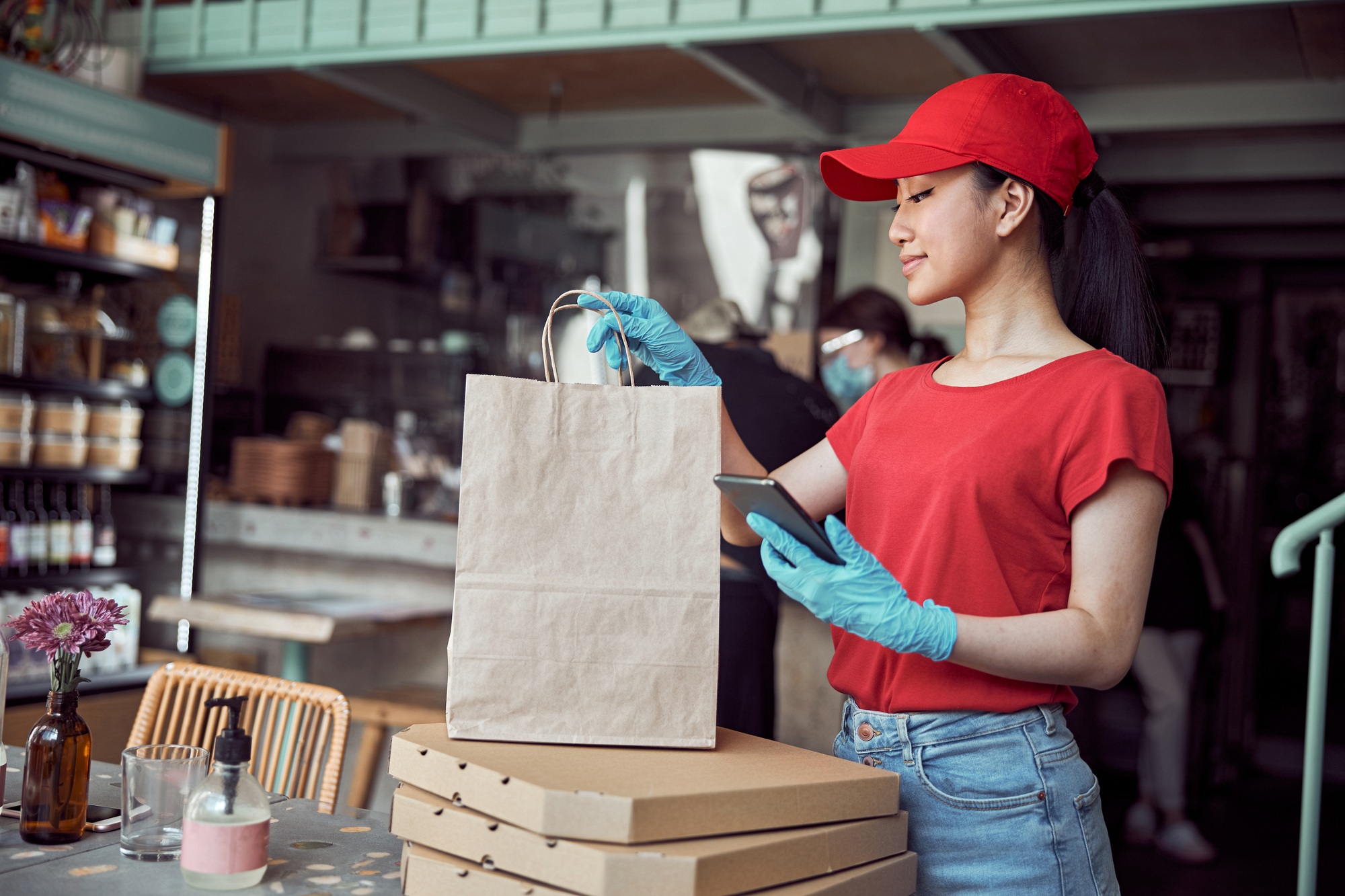 Asian employer working for food delivery service in cafe