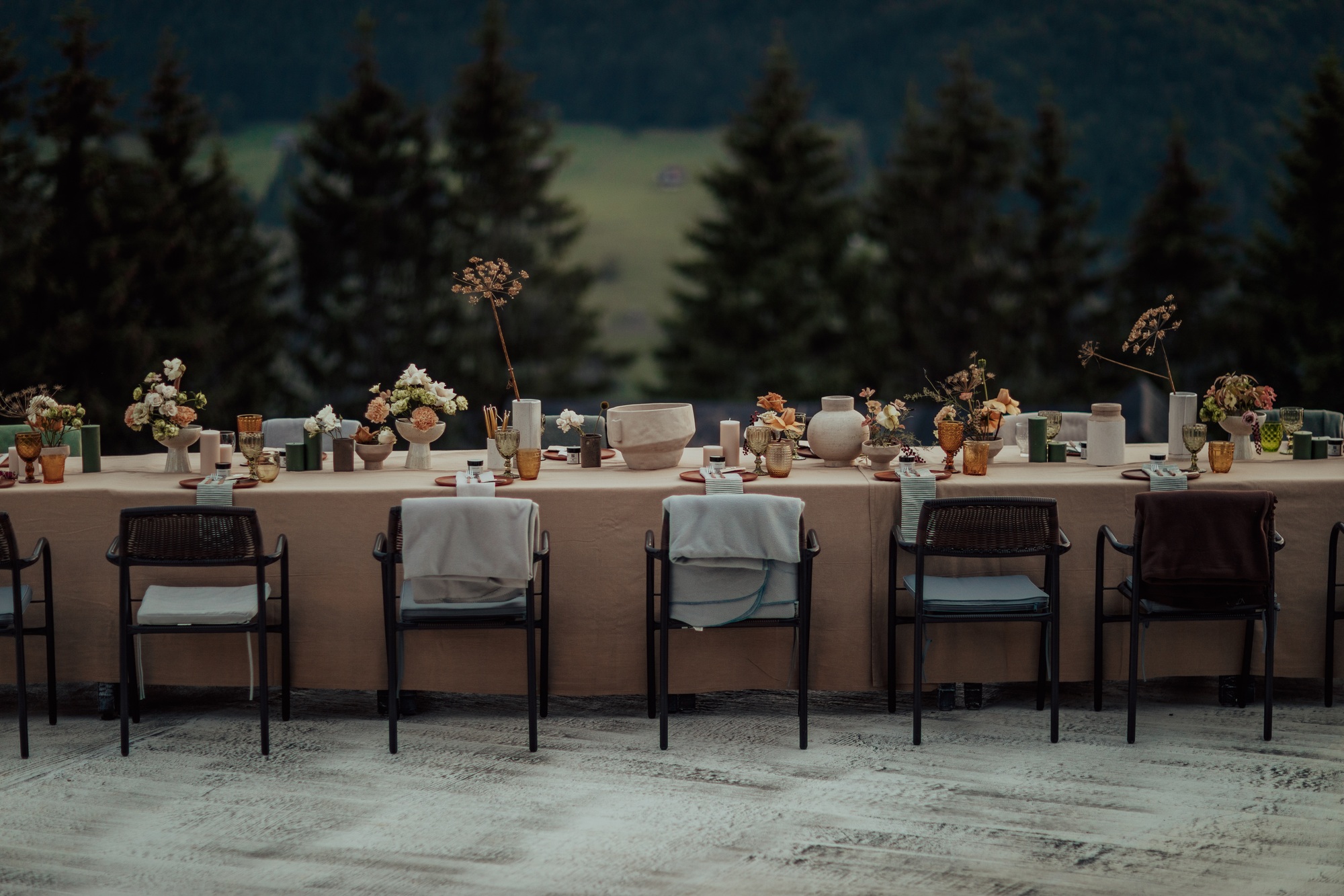 Table with orange dishware and floral decorations in an open-air restaurant - ready for celebration